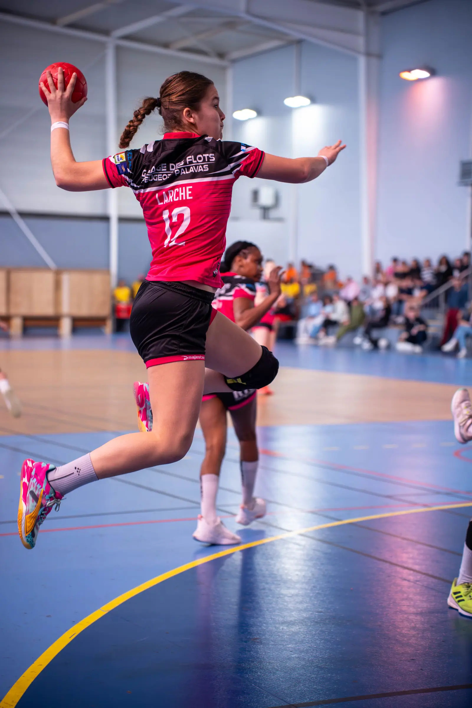 Jugadora de balonmano lanzando en suspensión durante un partido