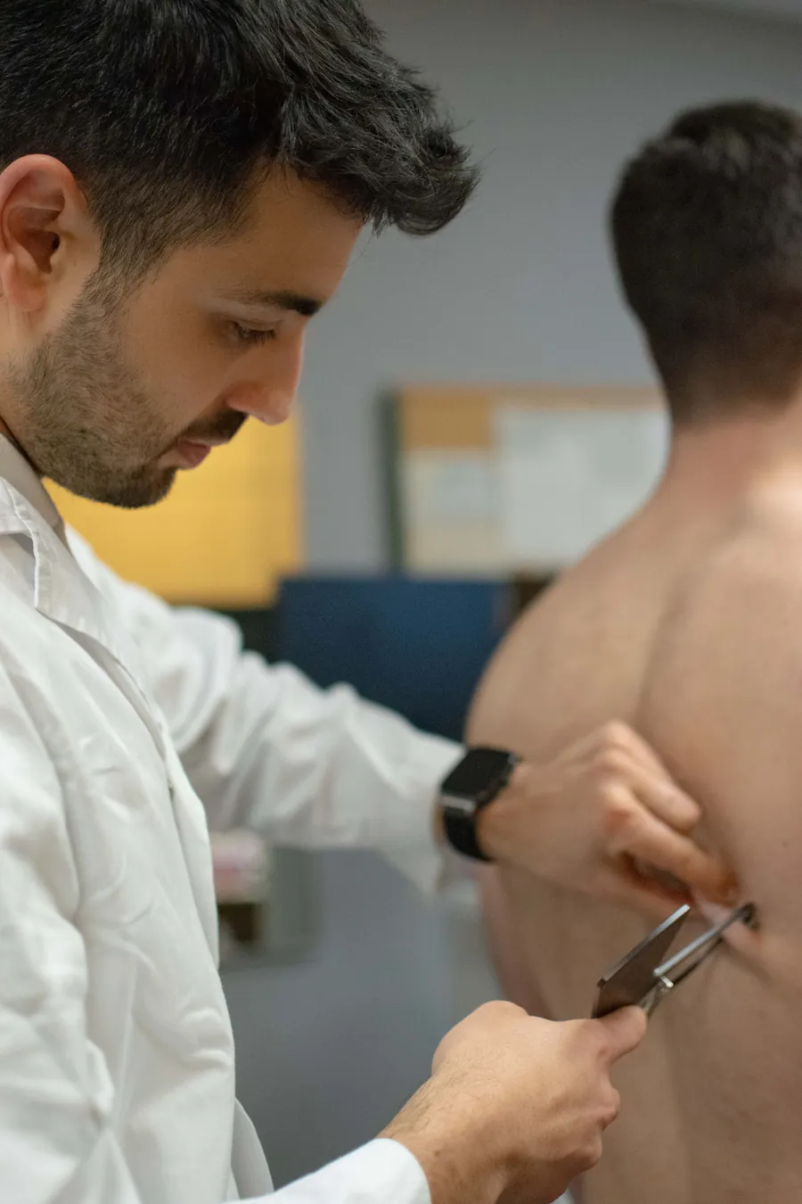 Plicómetro midiendo un pliegue cutáneo tricipital durante una valoración ISAK